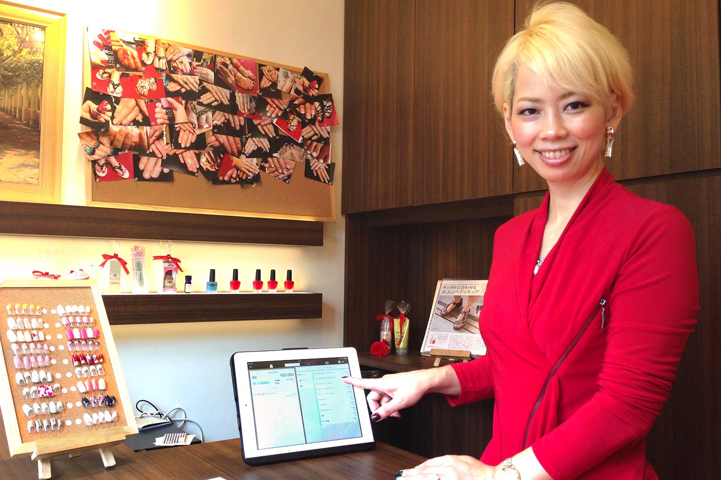 iPadレジの「ユビレジ」を指差す山崎店長